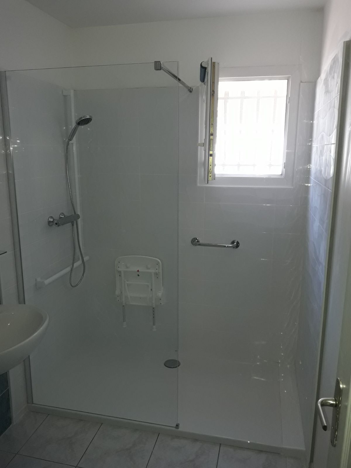 Douche accessible avec barre d'appui et siège